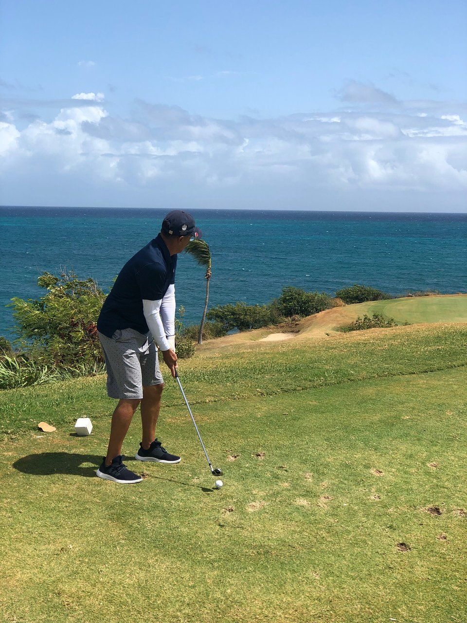 A man on resort golf course near the sea.