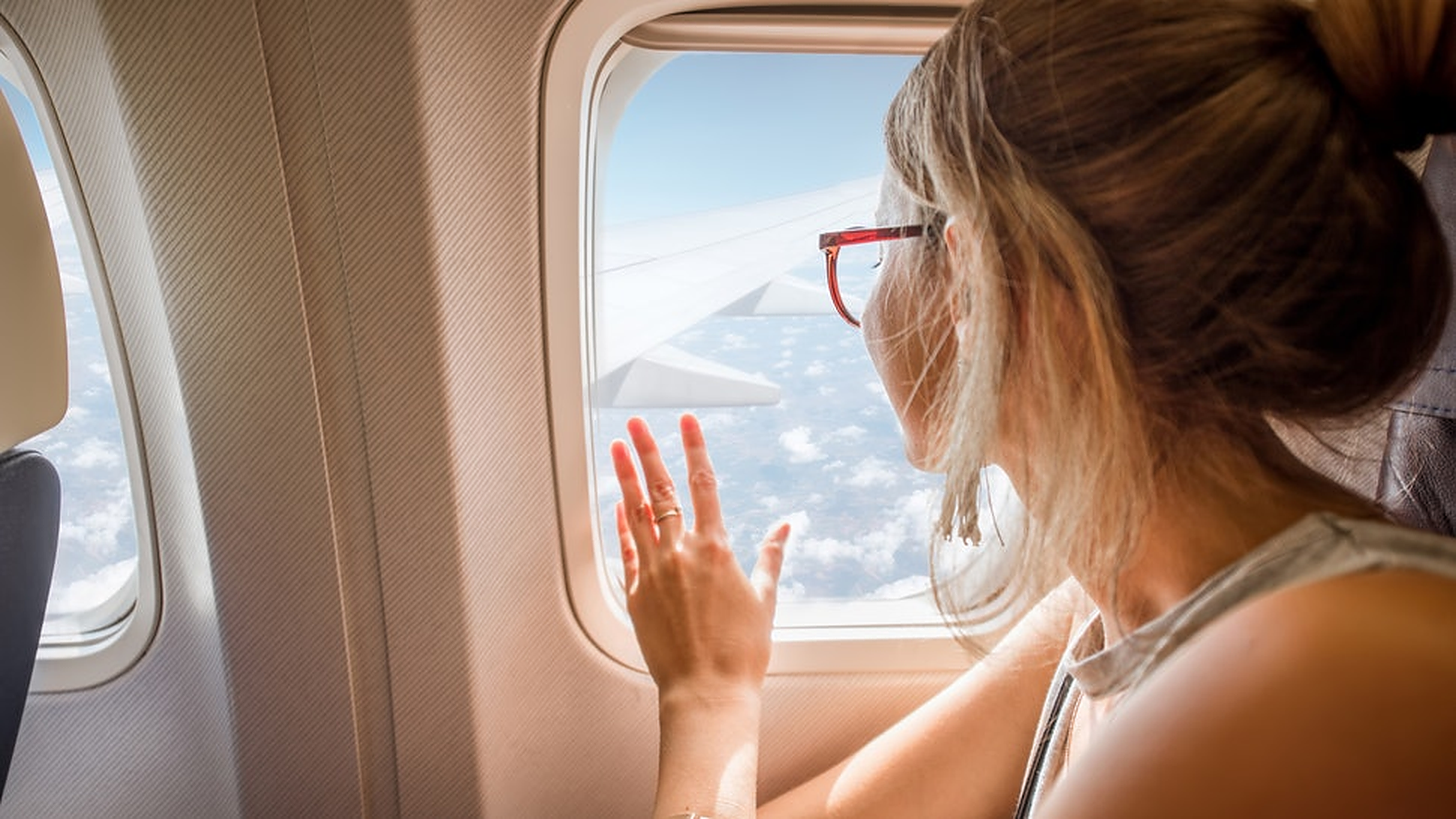Woman touching plane window.