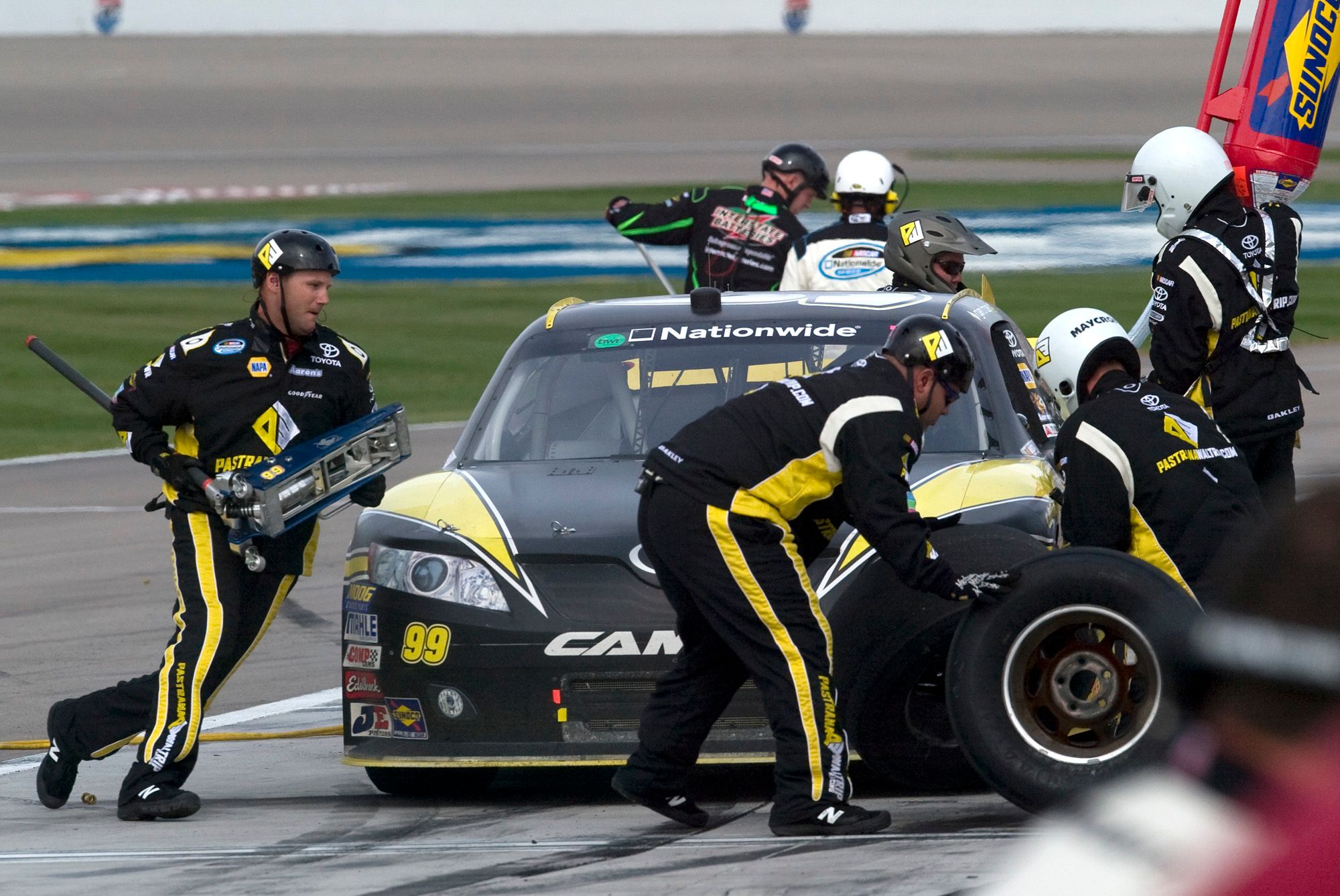 Nascar drivers working on a car