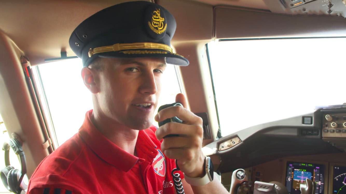 Pilot in cockpit making an announcement on intercom