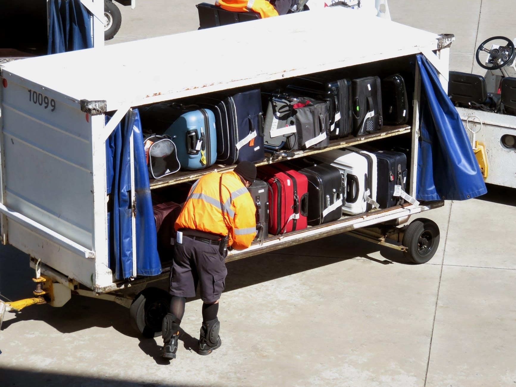 Man putting luggage on a cart 