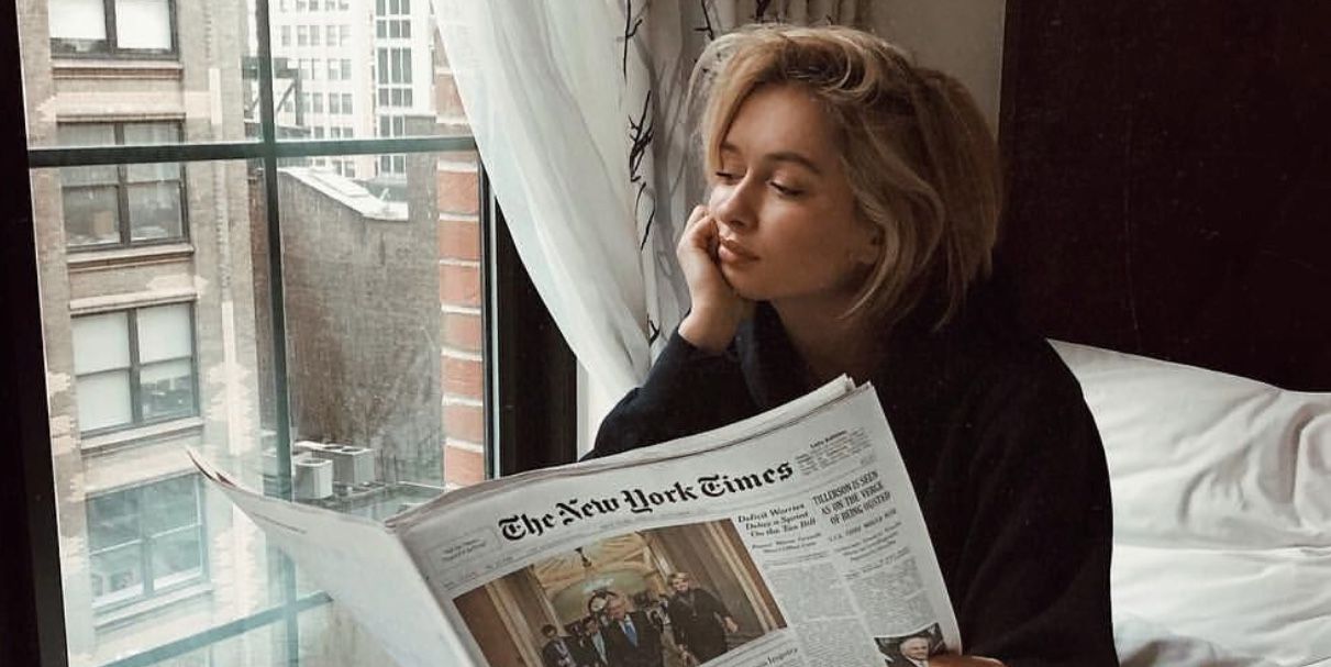 girl in bed reading new york times