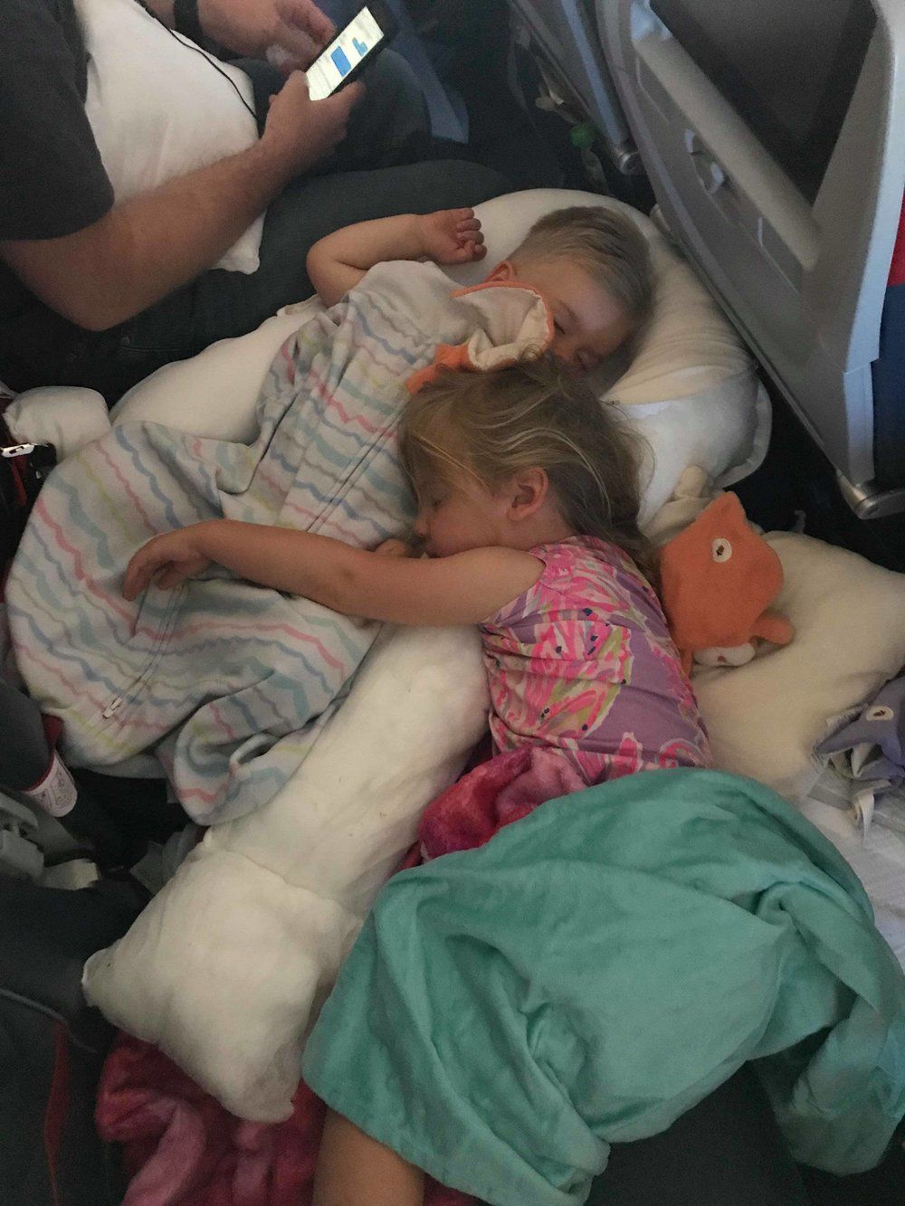 Kids peacefully sleeping in their airplane seats during flight