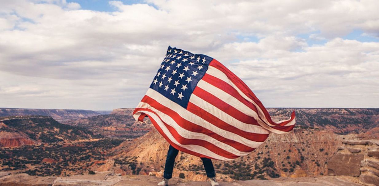 man with an american flag in the desert