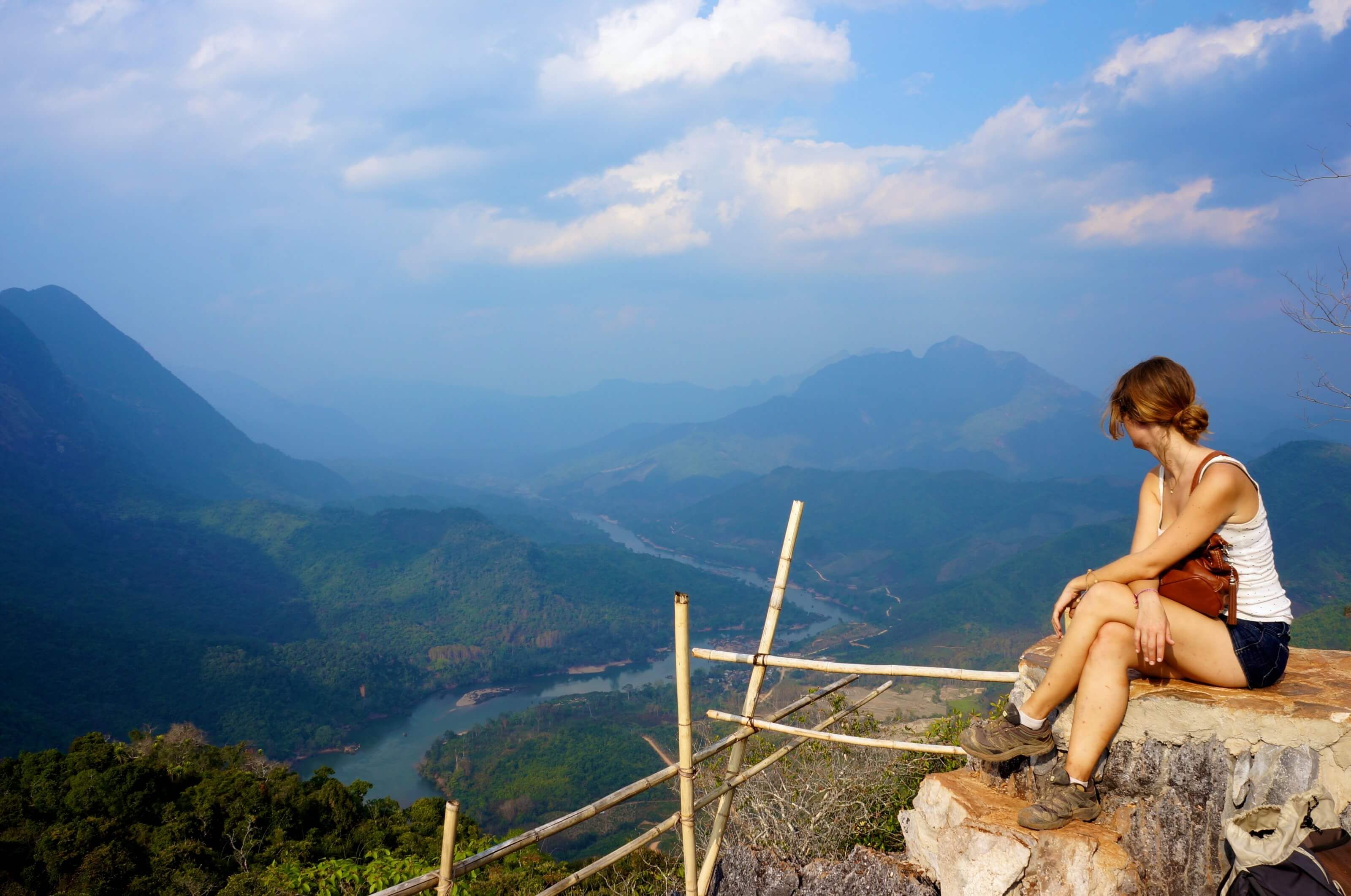 Woman looking over valleys and river in Laos