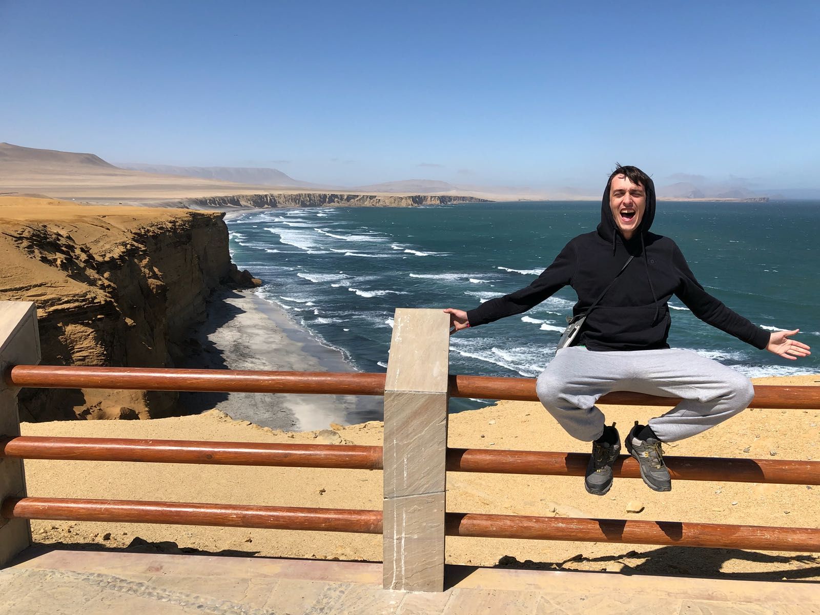 Man sitting on fence at Paracas