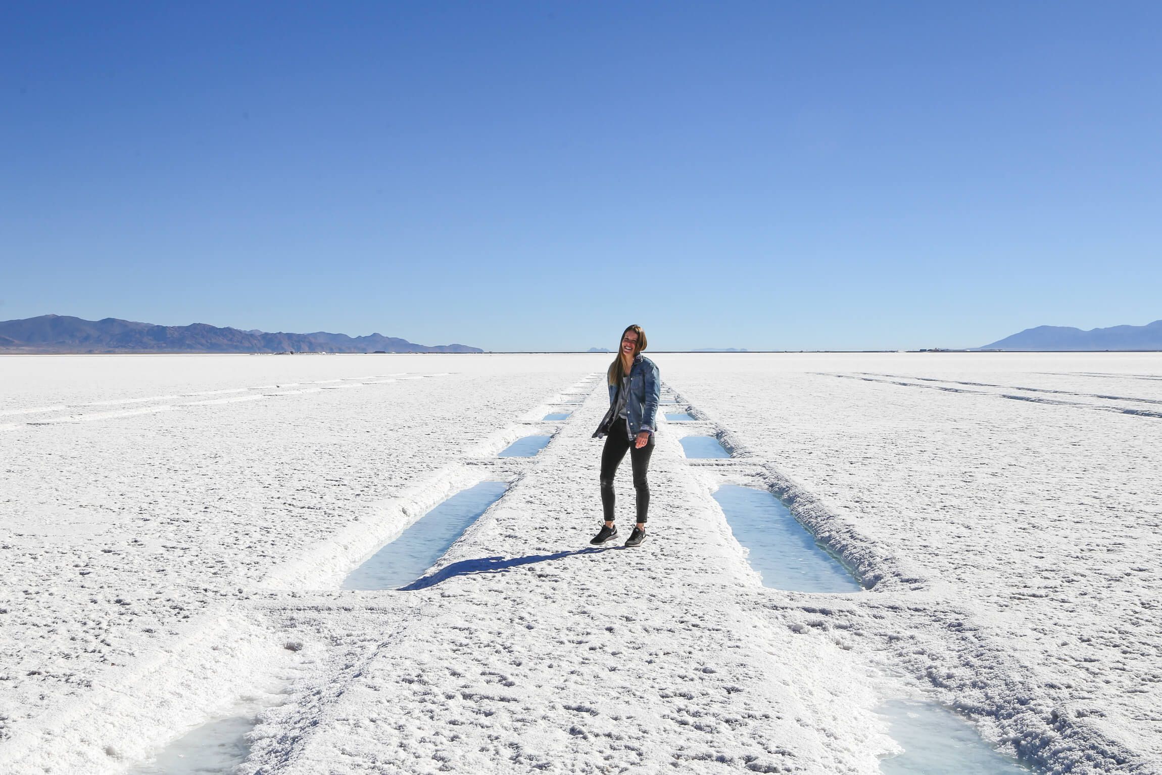 Woman standing between salt ponds