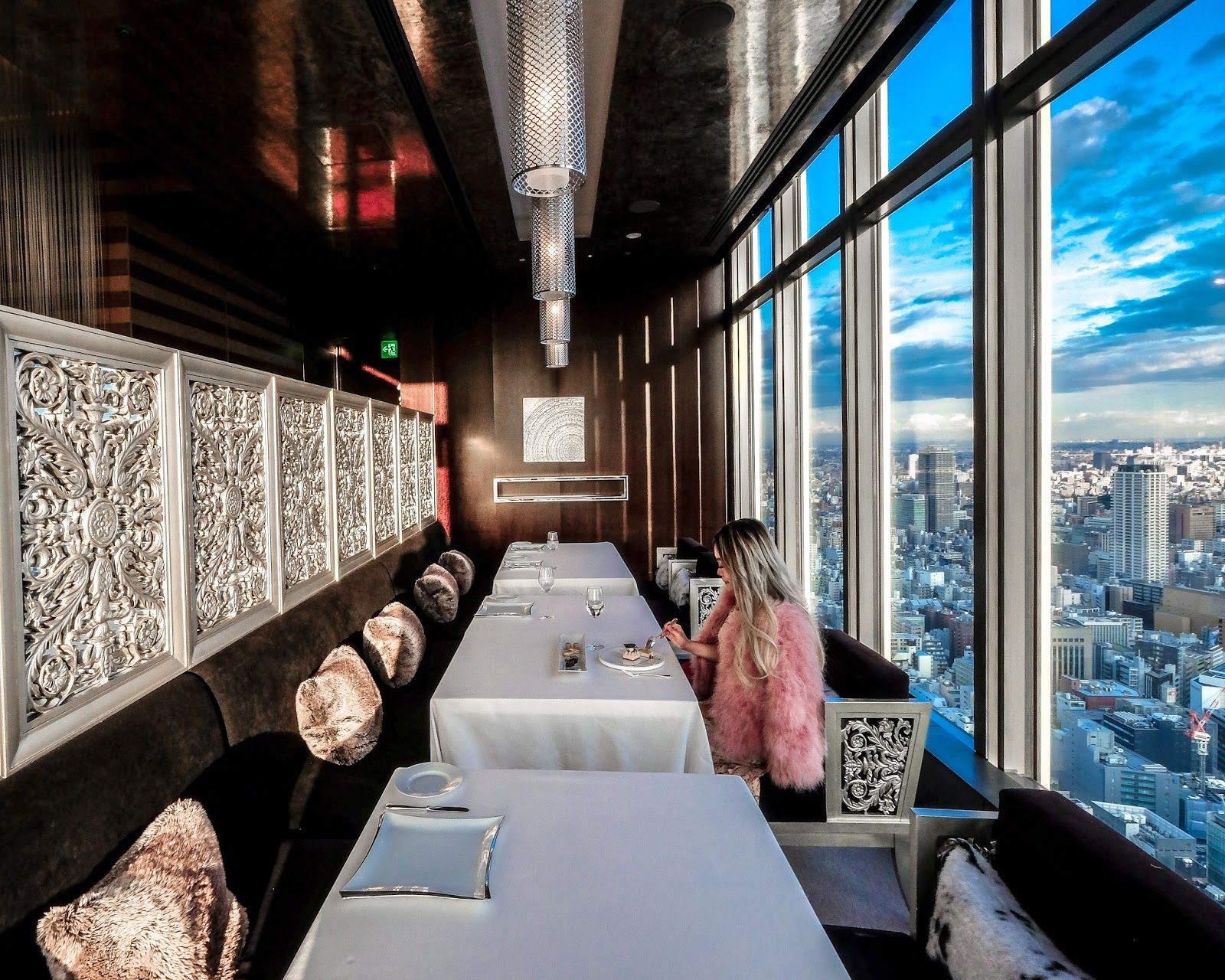 Woman in a pink fur coat eating at a restaurant on the top floor of Mandarin Oriental hotel Tokyo
