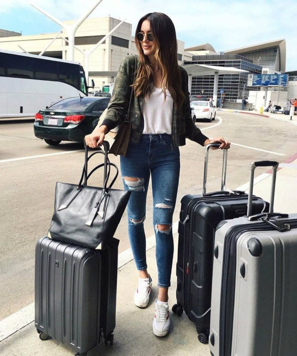 girl outside airport with luggage
