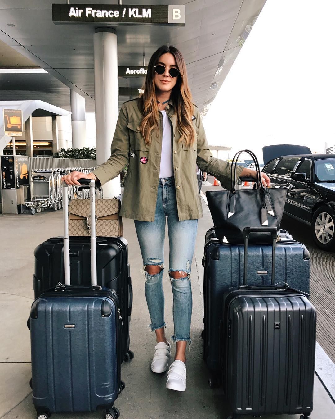 girl standing in airport with suitcases