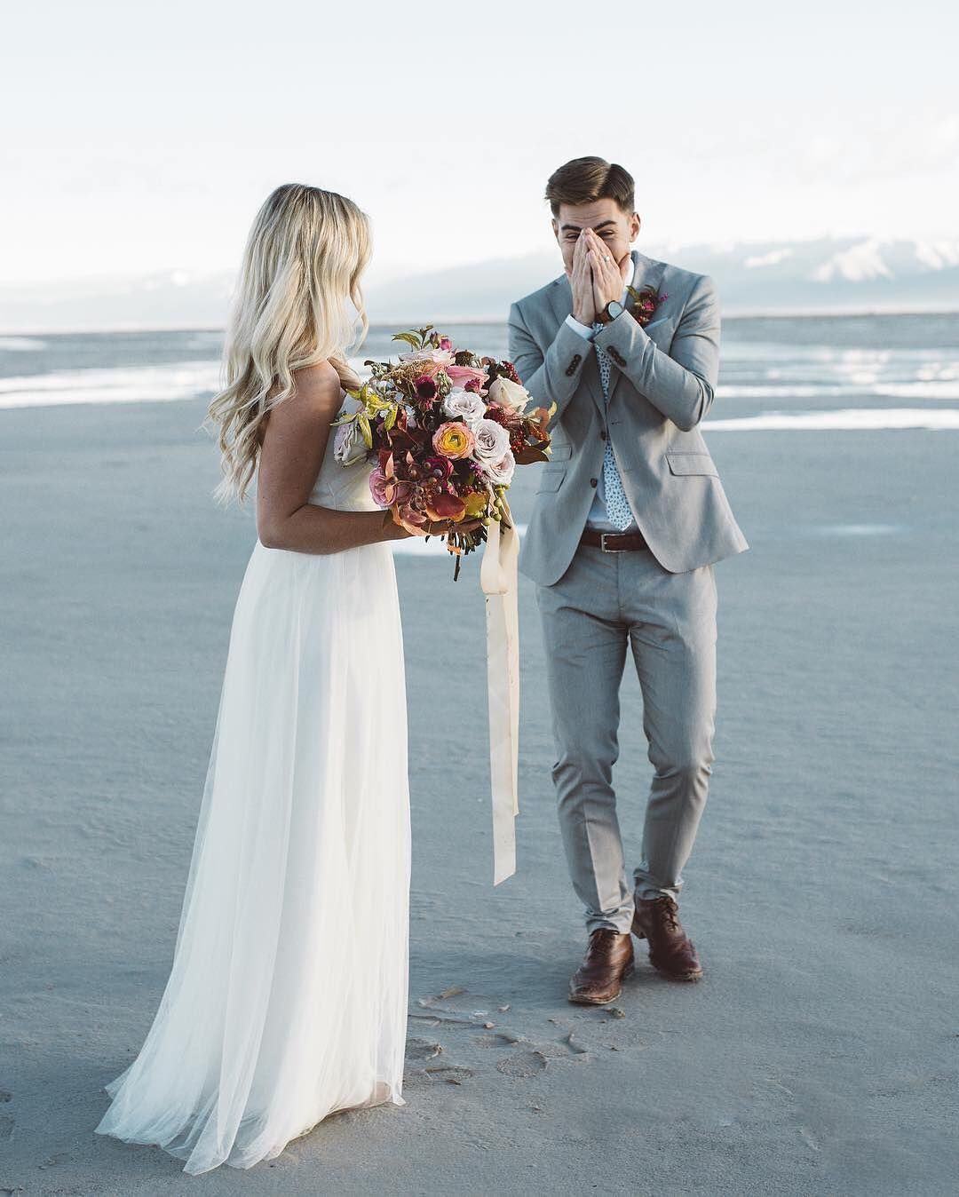 a groom sees his bride for the first time on the beach 