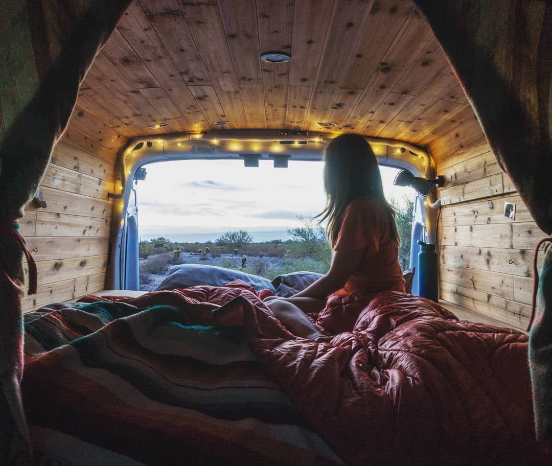 girl looking out from a camper van