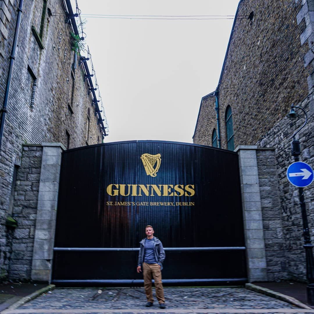 person standing in front of gate at guinness brewery dublin