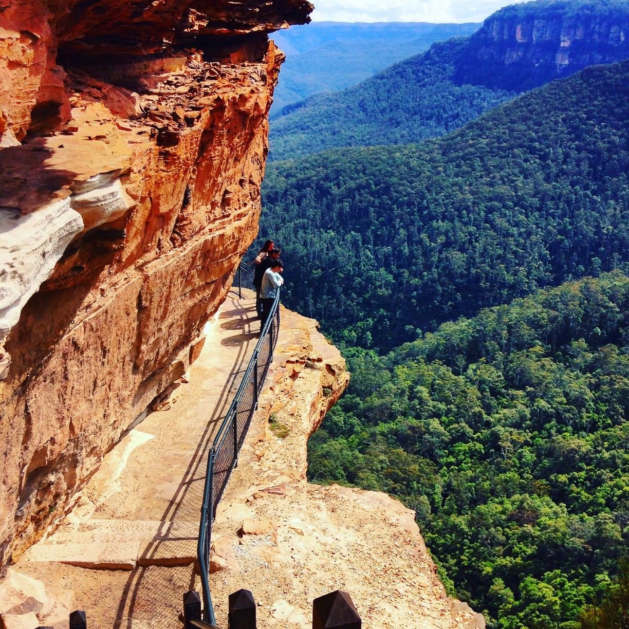 Group of people looking over a railing from a rock outcropping at Blue Mountains National Park Australia