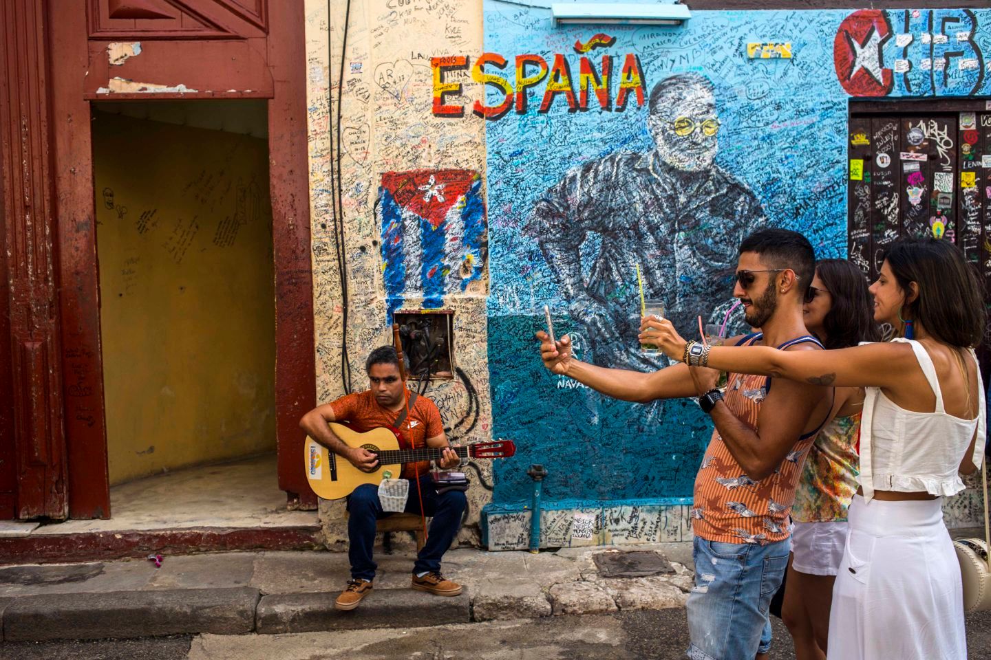 Group of people taking selfies on the street in Cuba