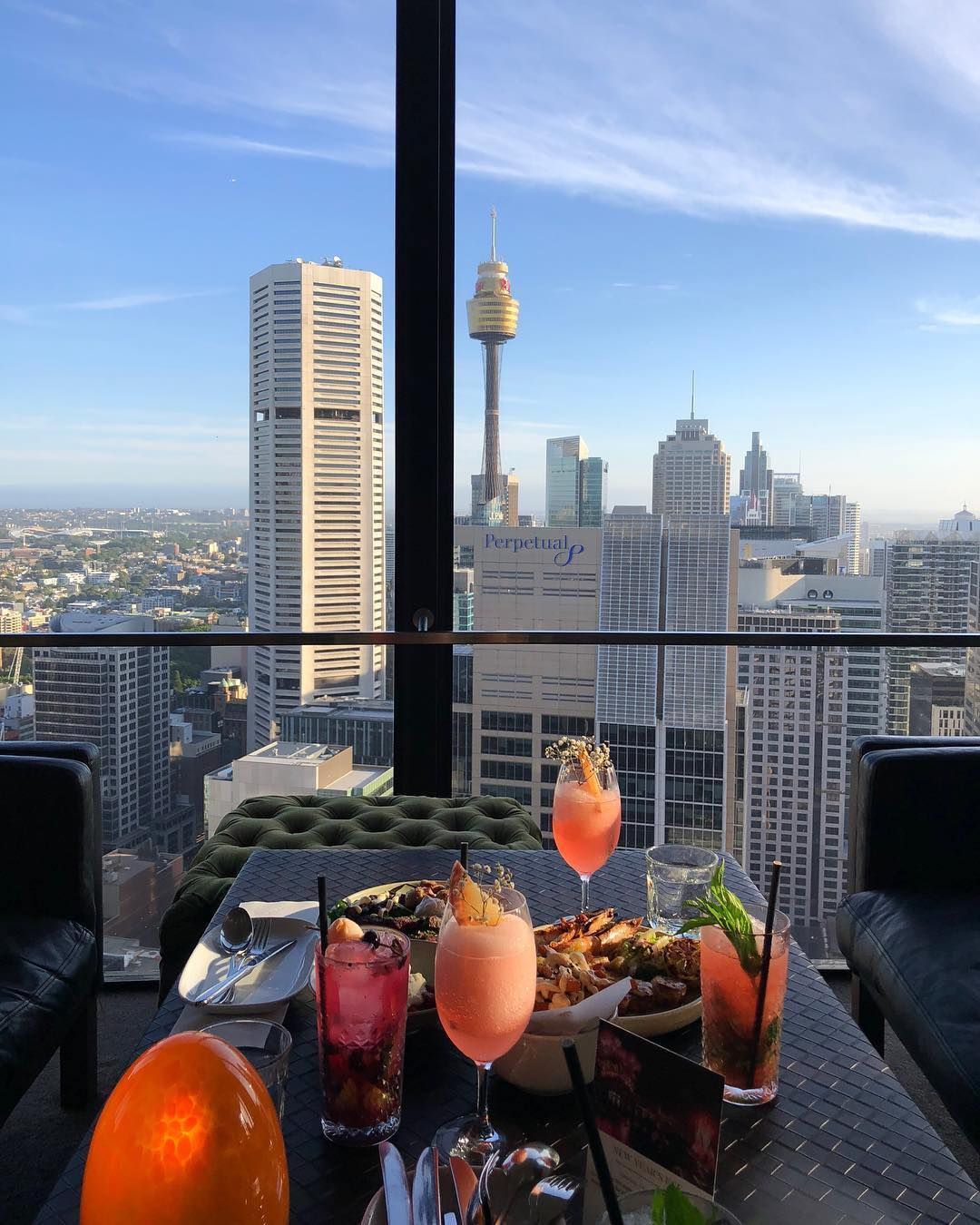 Food and drinks on a table with a view of Sydney and Sydney Tower in Australia