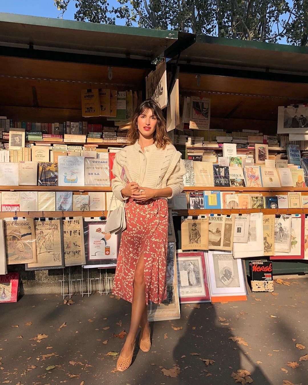 Woman posing in front of books and papers on the street in France