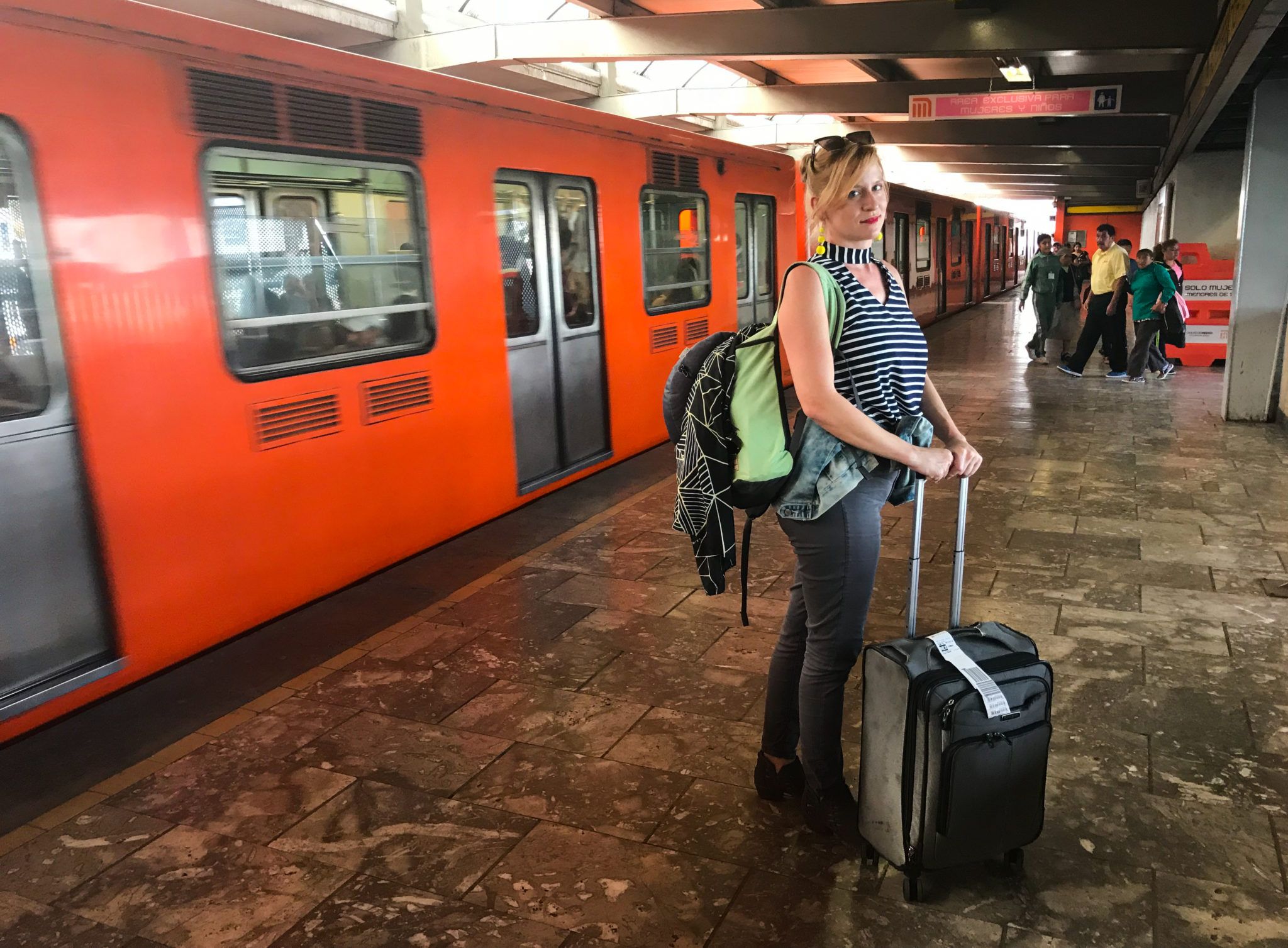 Woman standing in metro station in Mexico next to train
