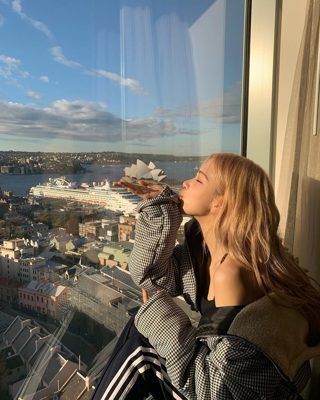 Woman at a window overlooking Sydney Harbour