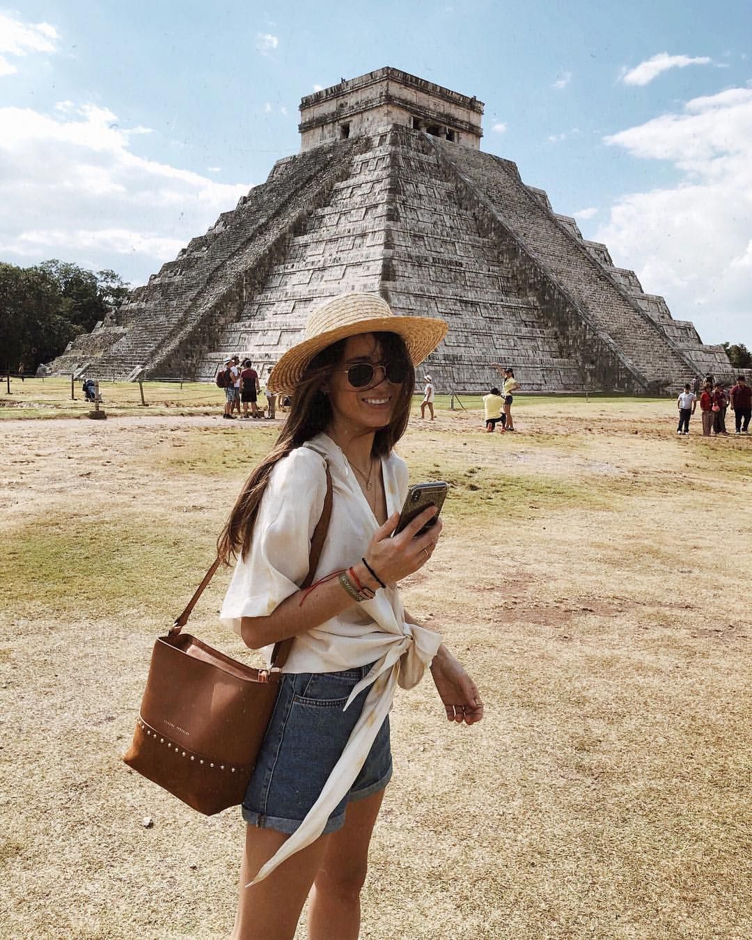 Woman standing in front of Chichen Itza in Mexico