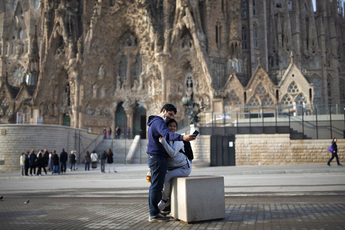 Couple taking selfie in front of Sagrada Familia in Barcelona, Spain.