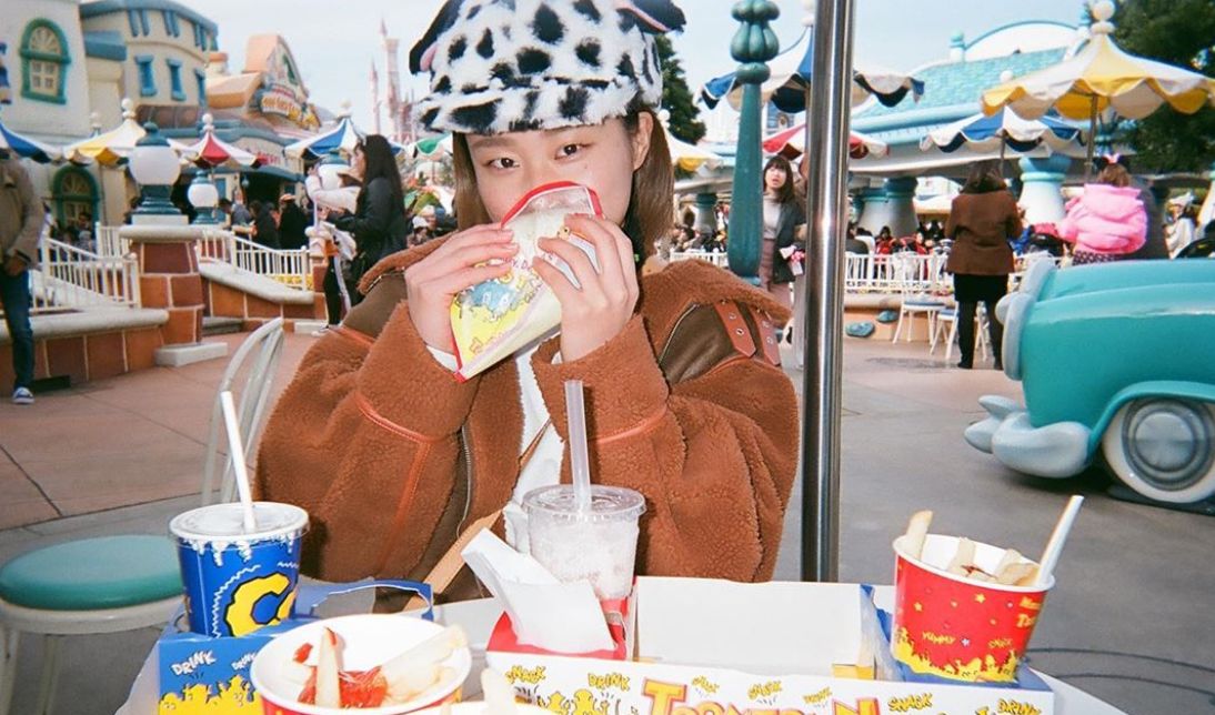 Girl eating fast food at Tokyo Disney