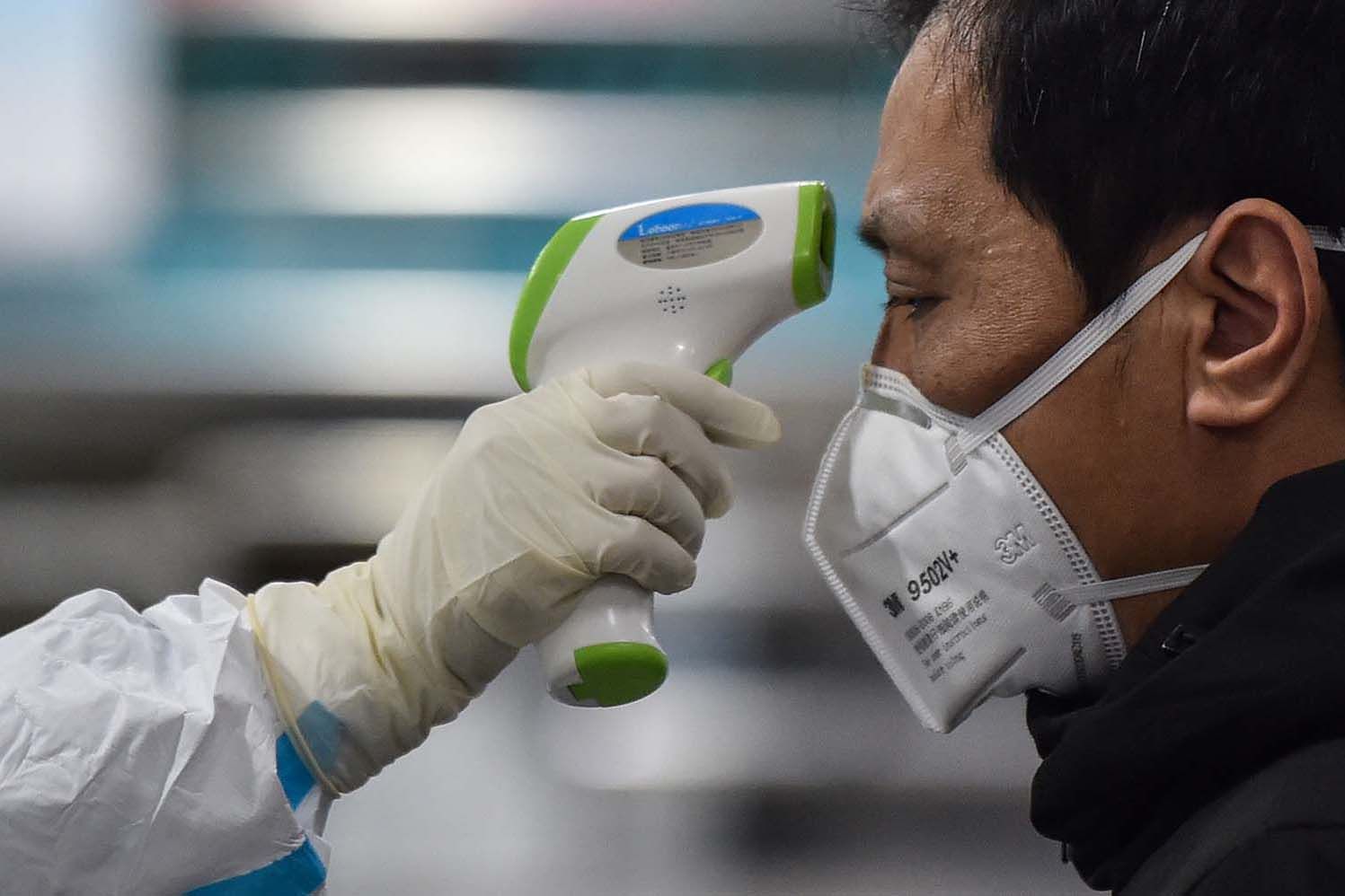 Man gets temperature taken for Covid 19 testing in China