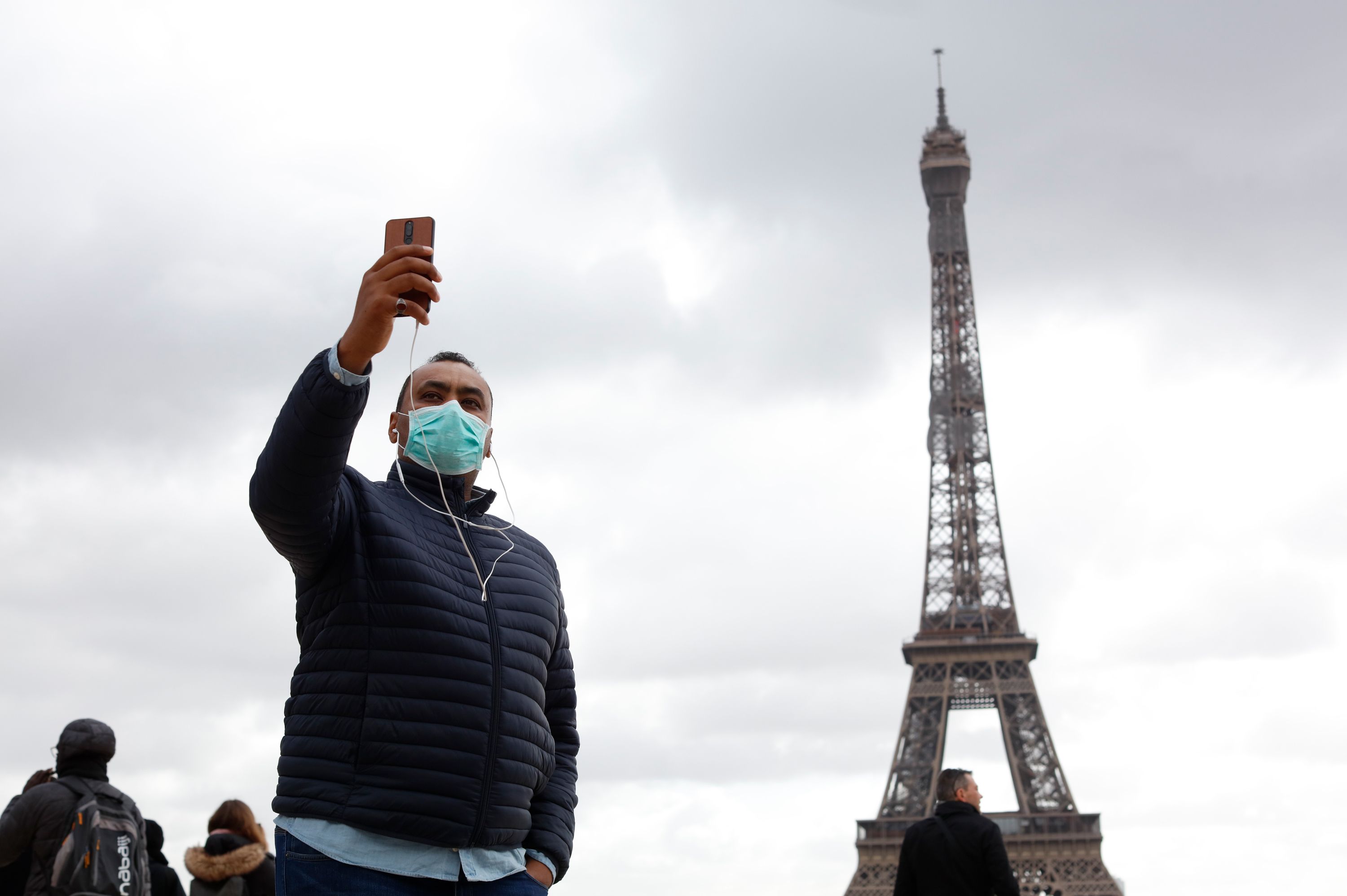 Tourist taking selfie in front of Eiffel Tower