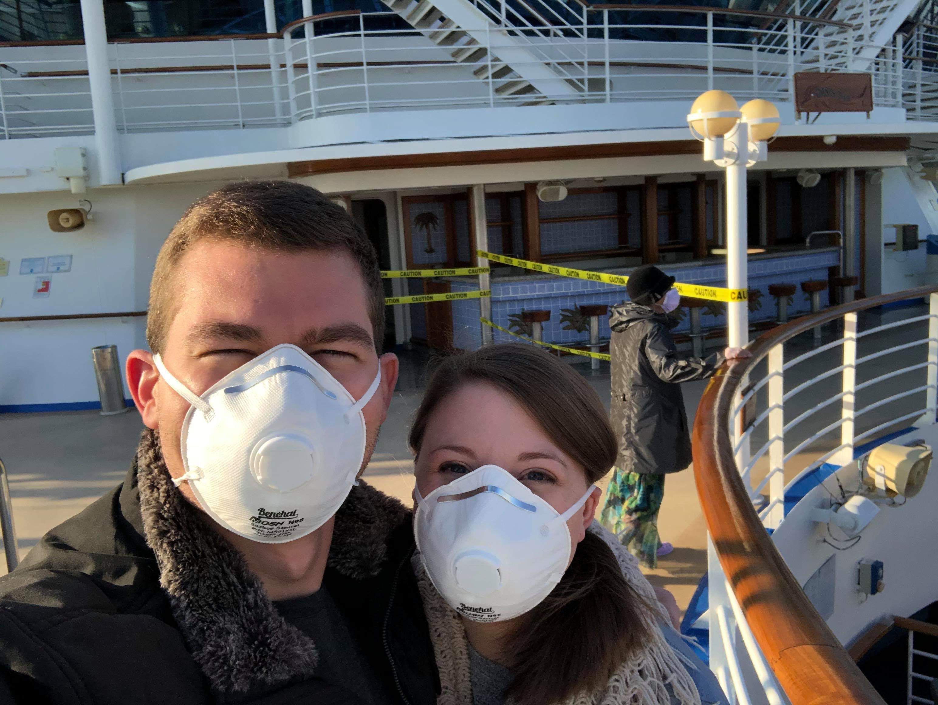 people wearing masks in front of cruise ship