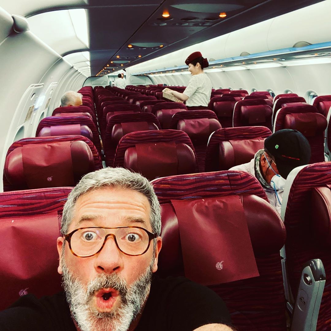 guy taking a selfie on an almost empty plane qatar airways