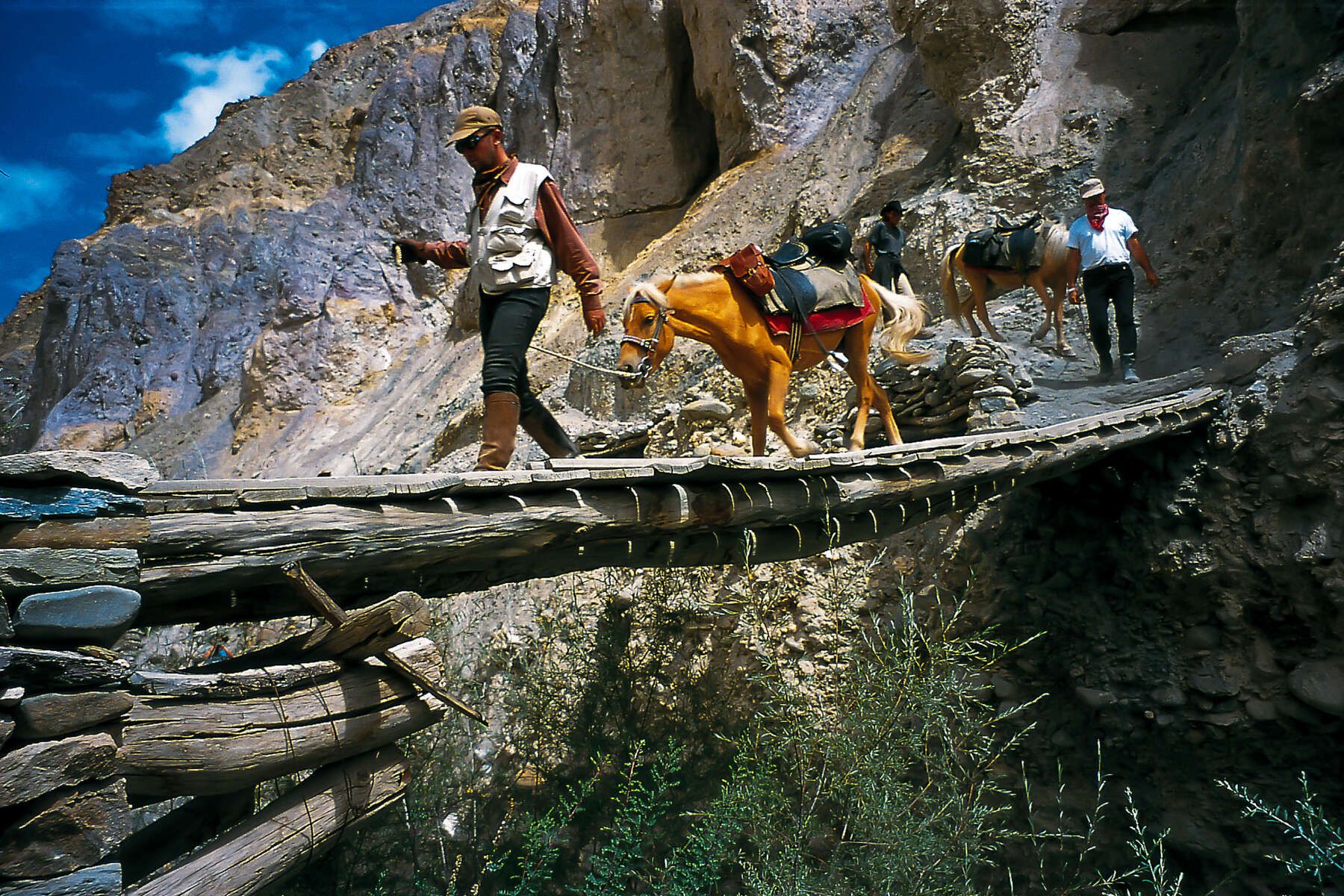 Horses and people crossing small bridge in Ladakh India