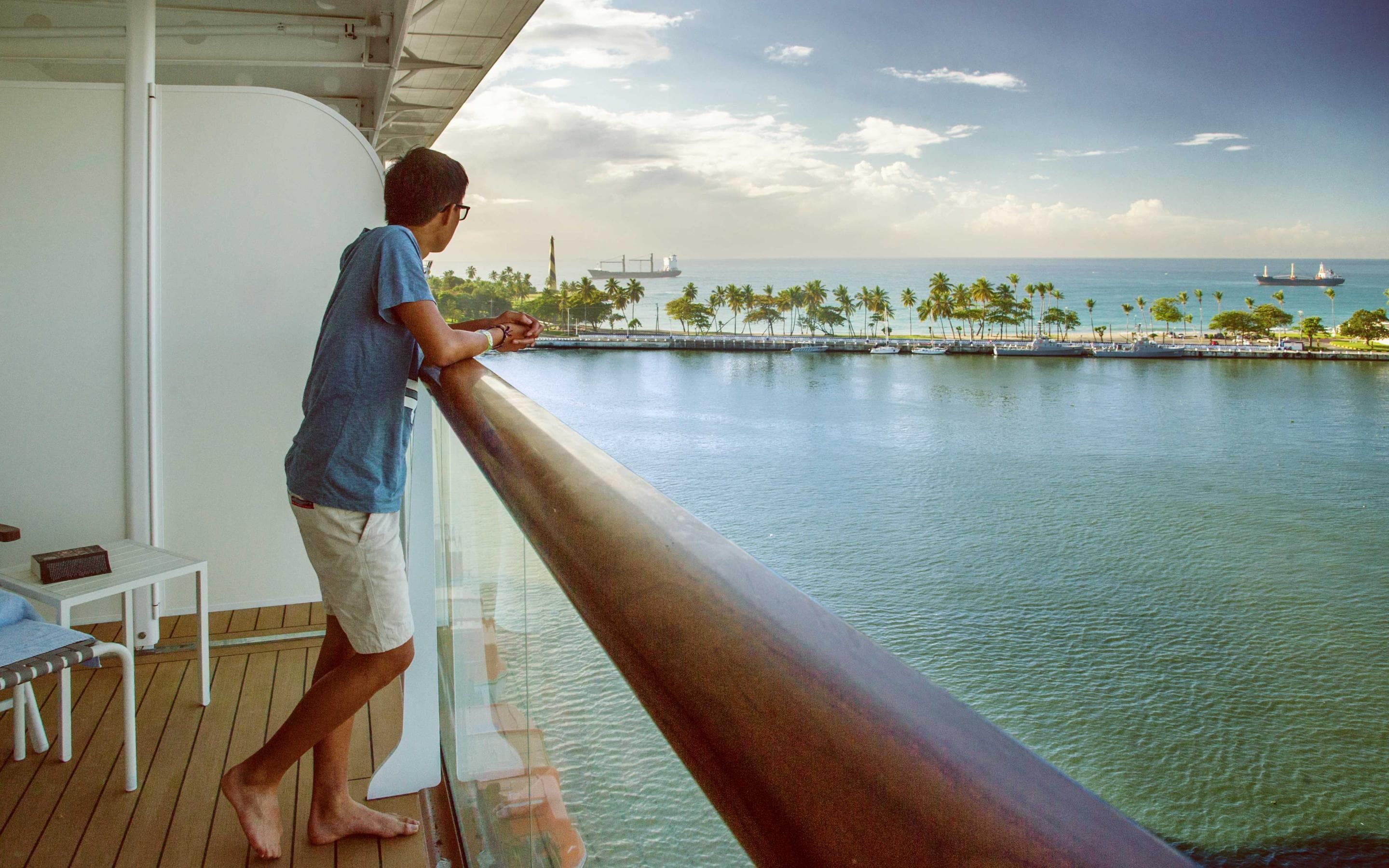 Man looking out over the water from cruise ship balcony