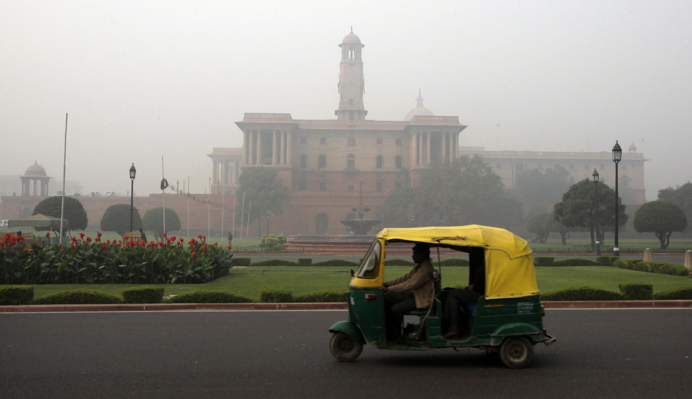 Rickshaw driving on New Delhi street in the fog