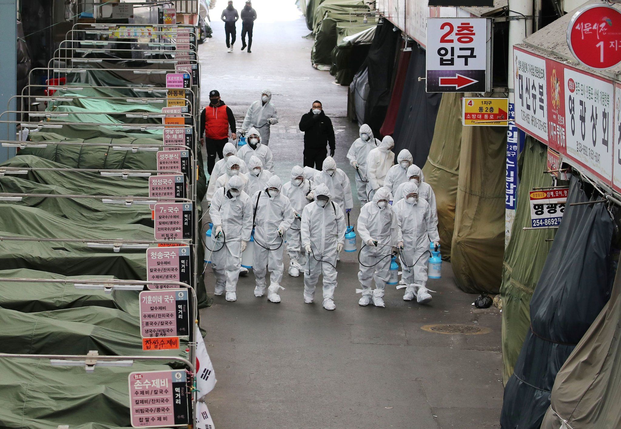 military personnel sanitize and disinfect a market in hazmat suites