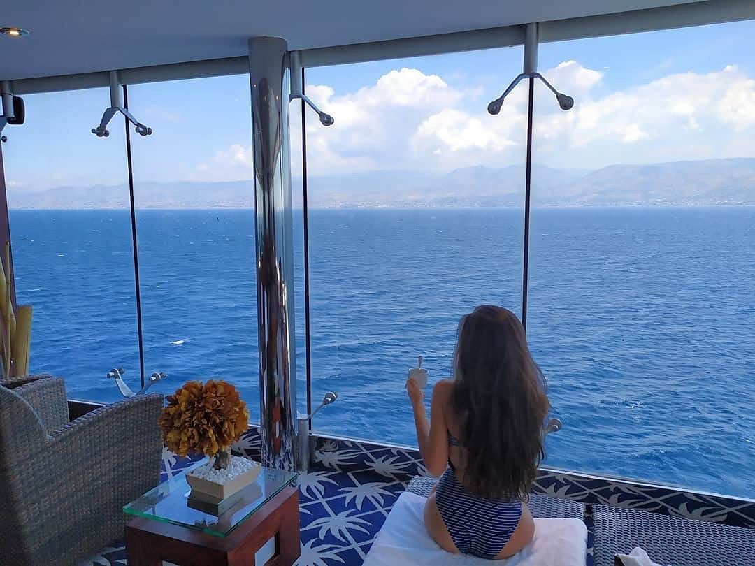 Woman posing in a bikini by cruise ship windows