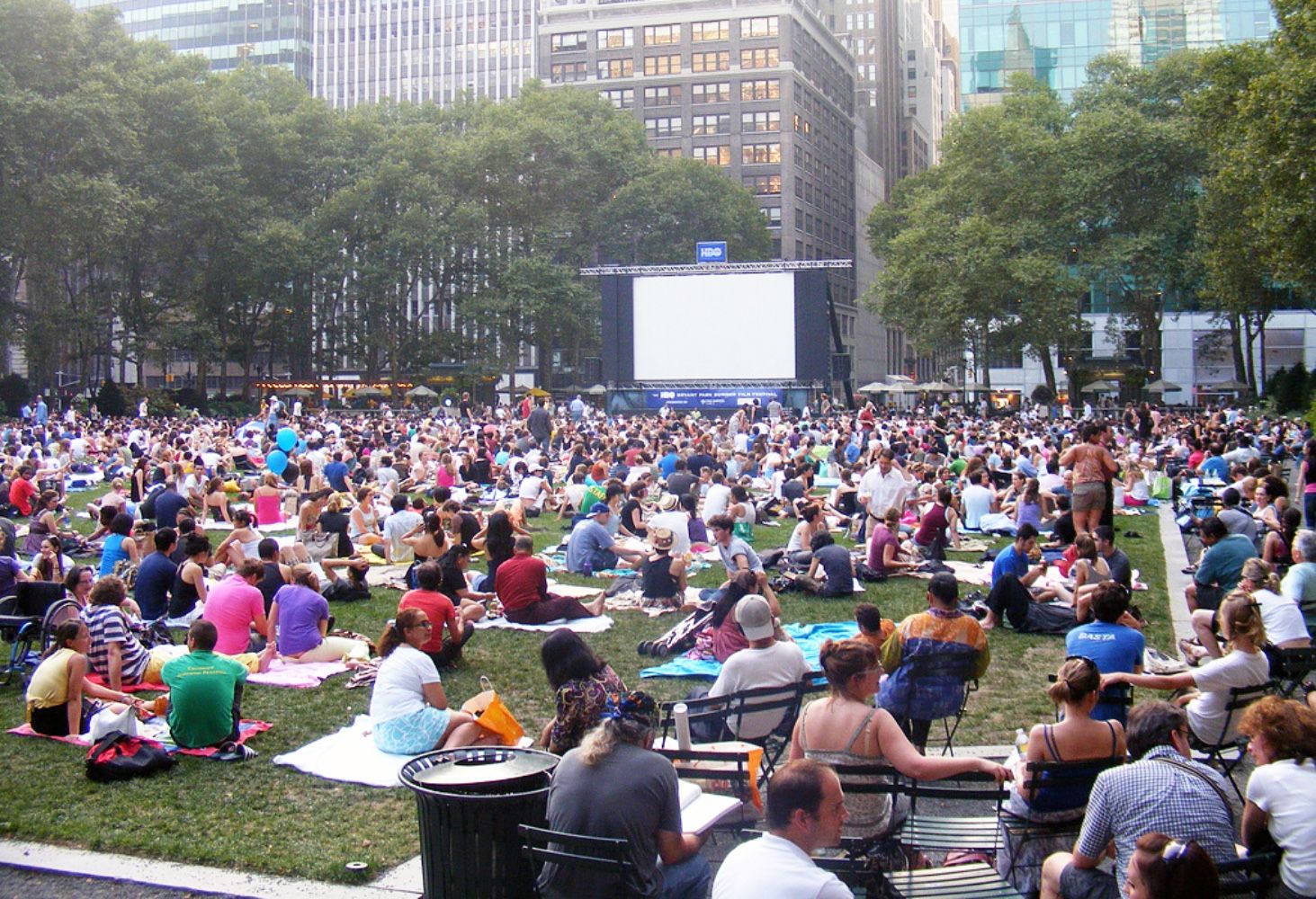 group of people sitting on lawn watching movie bryant park