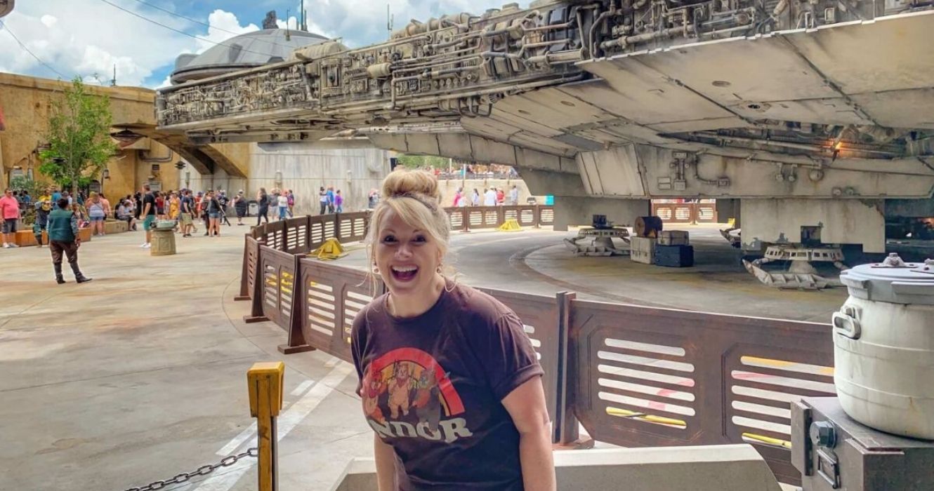 Tourist posing by the Millennium Falcon at Star Wars exhibit at Disneyland