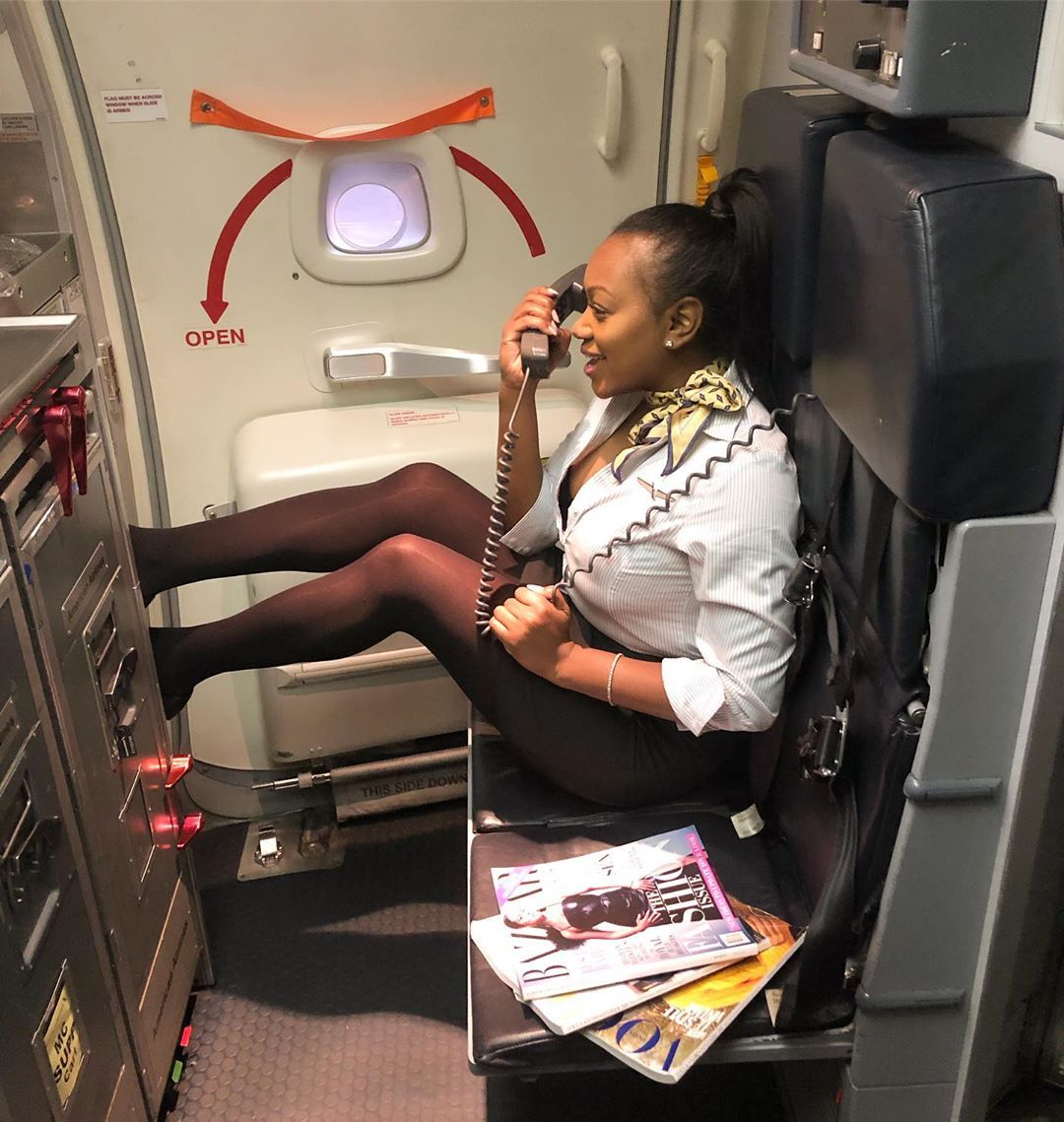 Flight attendant sitting next to magazines