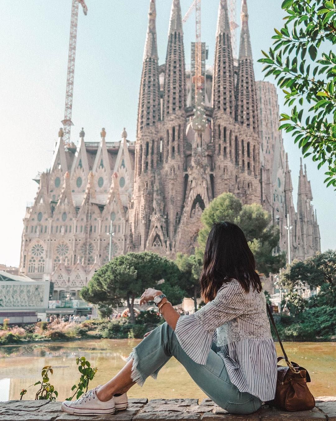 Girl sitting directly in front of La Sagrada Familia