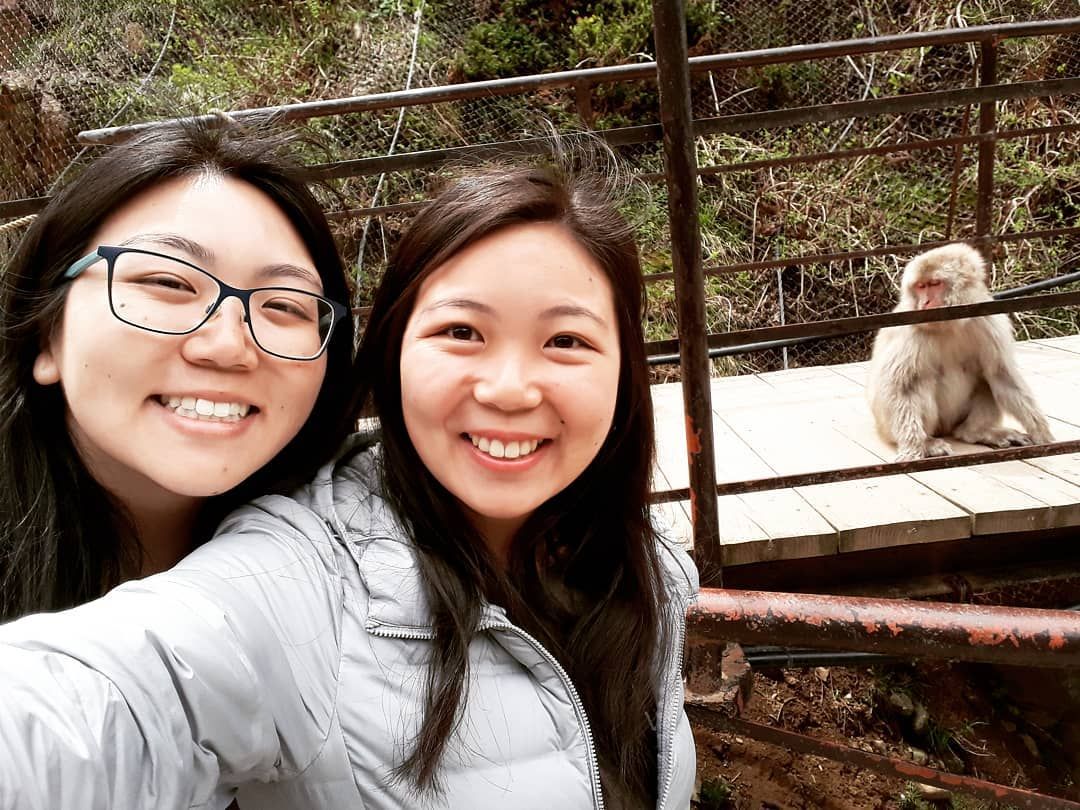 Women posing with a monkey