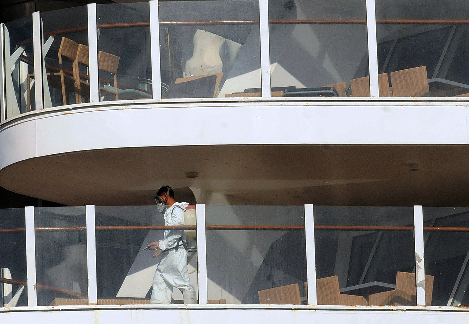 employees in hazmat suits disinfecting a cruise ship 
