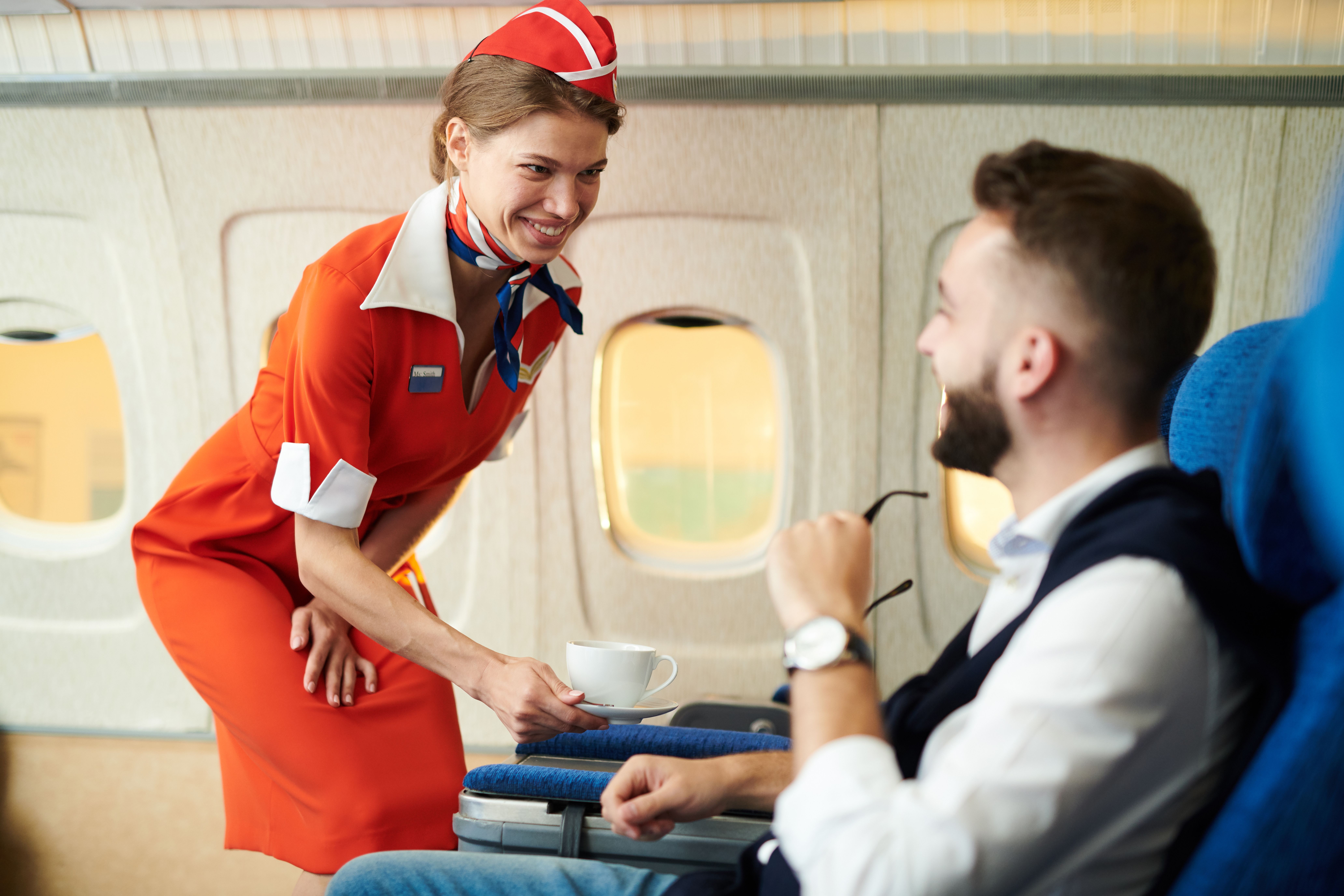a flight attendant speaking to a passenger