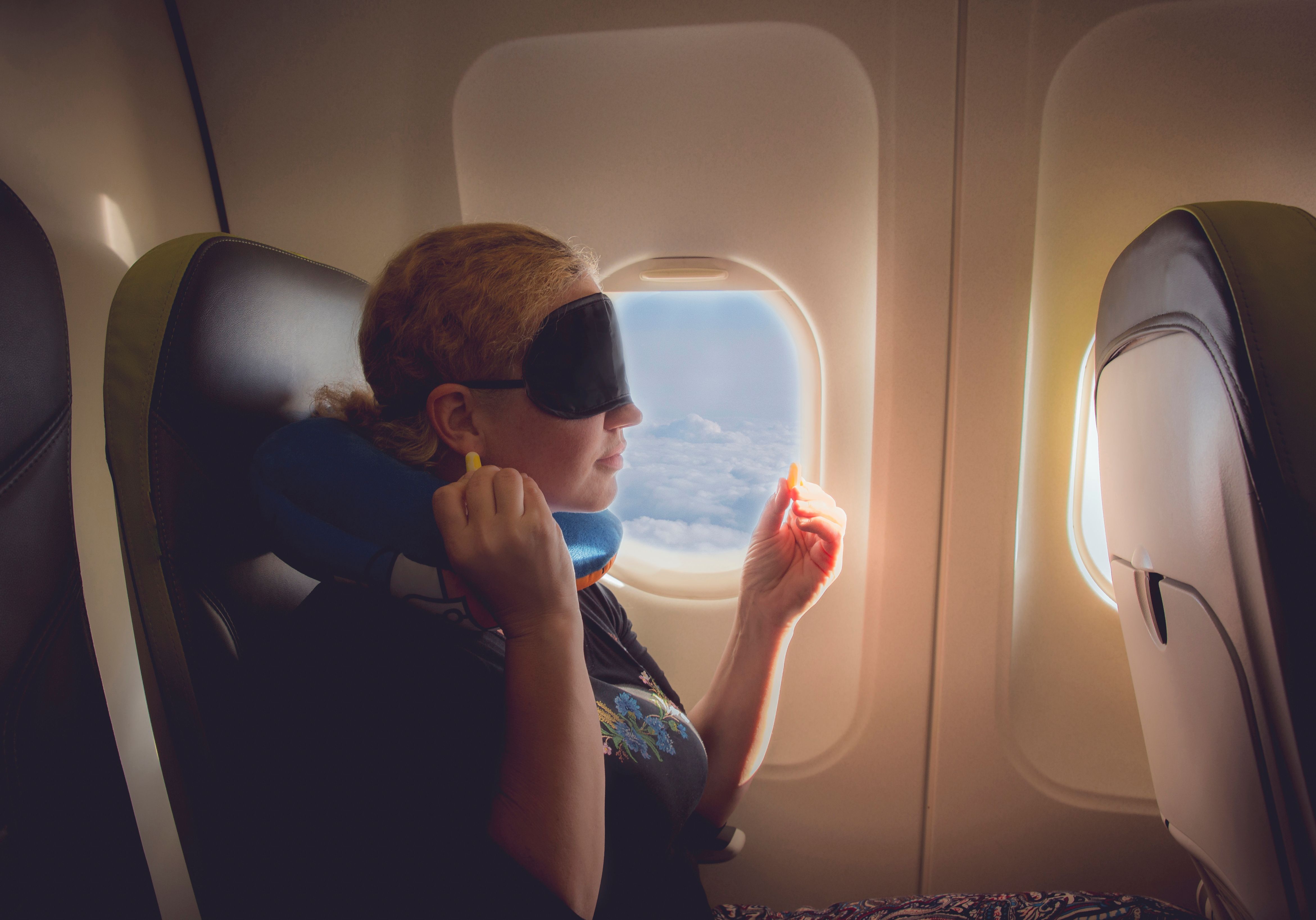 a plane passenger with an eye mask and earplugs