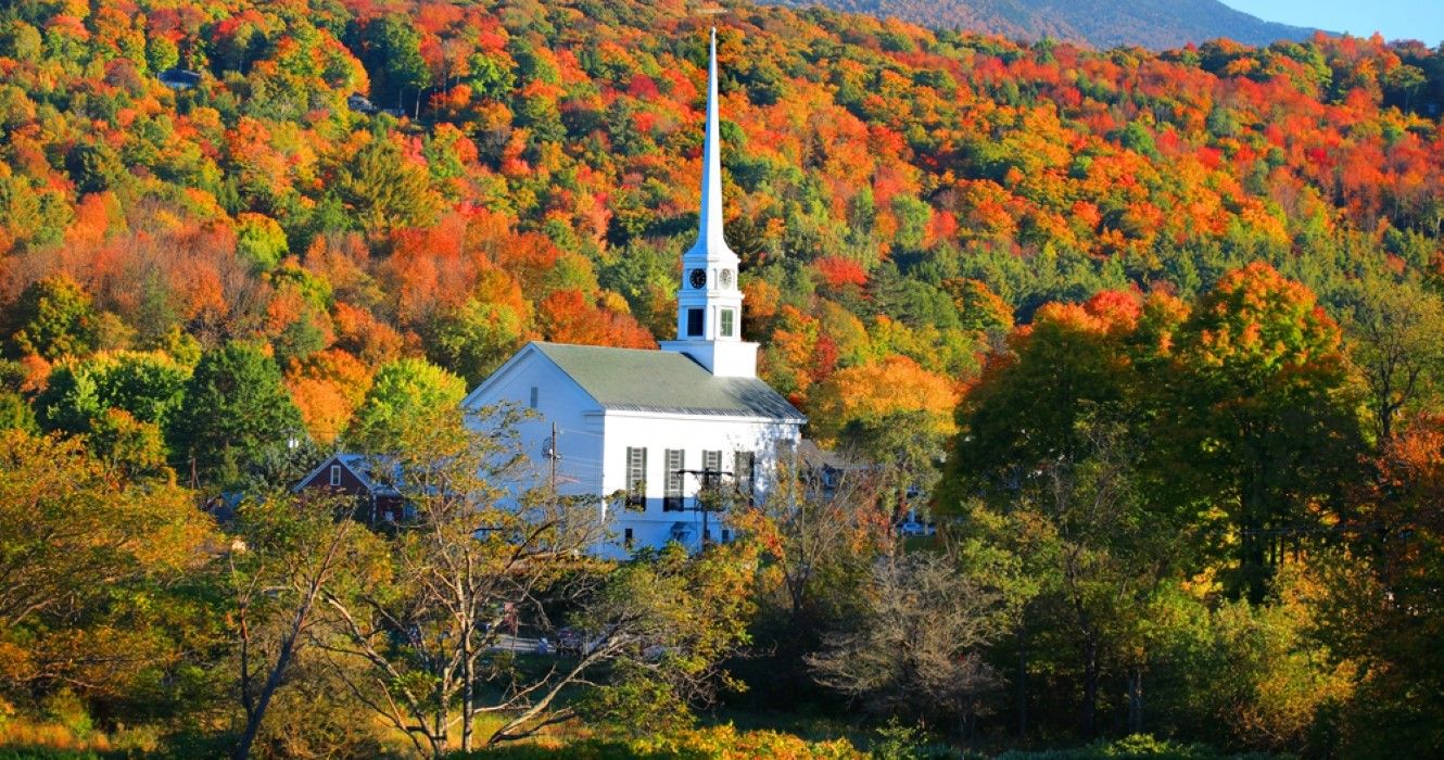 Church in Stowe set amidst vibrant tress during the fall, Vermont 