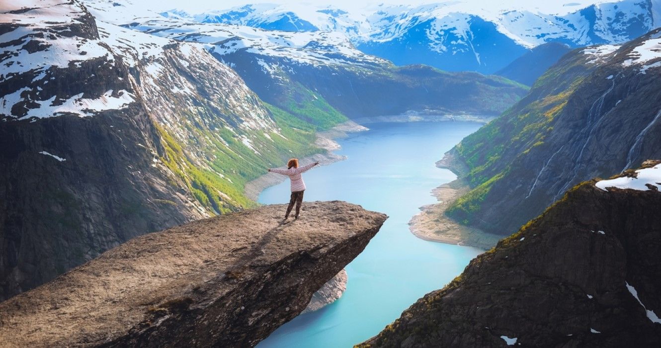 A person on a cliff overlooking a lake in Norway