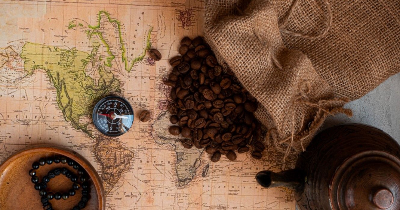 Coffee beans, world map and compass