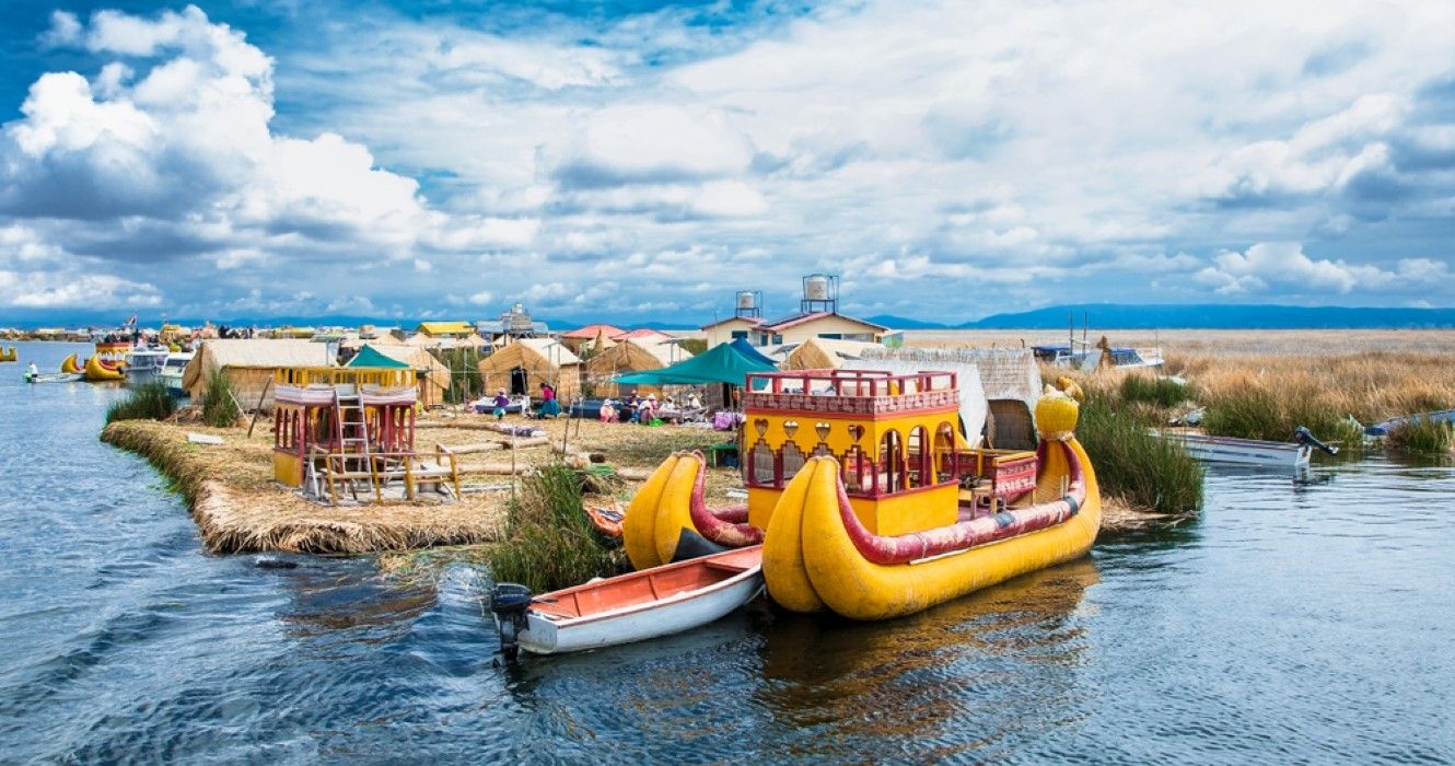 Totora boat with tourists on Titicaca lake, Uros, Peru