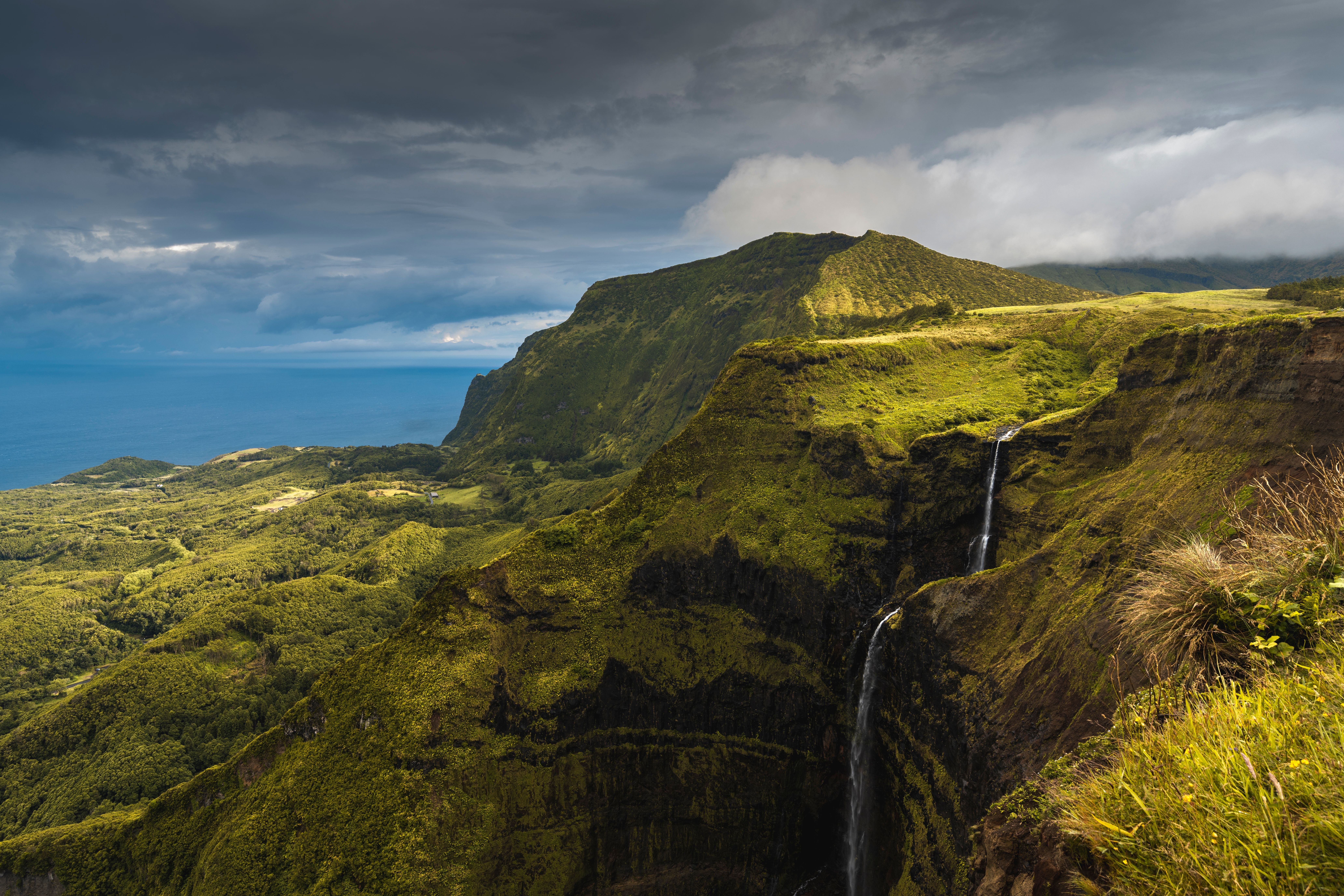 Waterfalls with green volcanic slopes in the Azores.