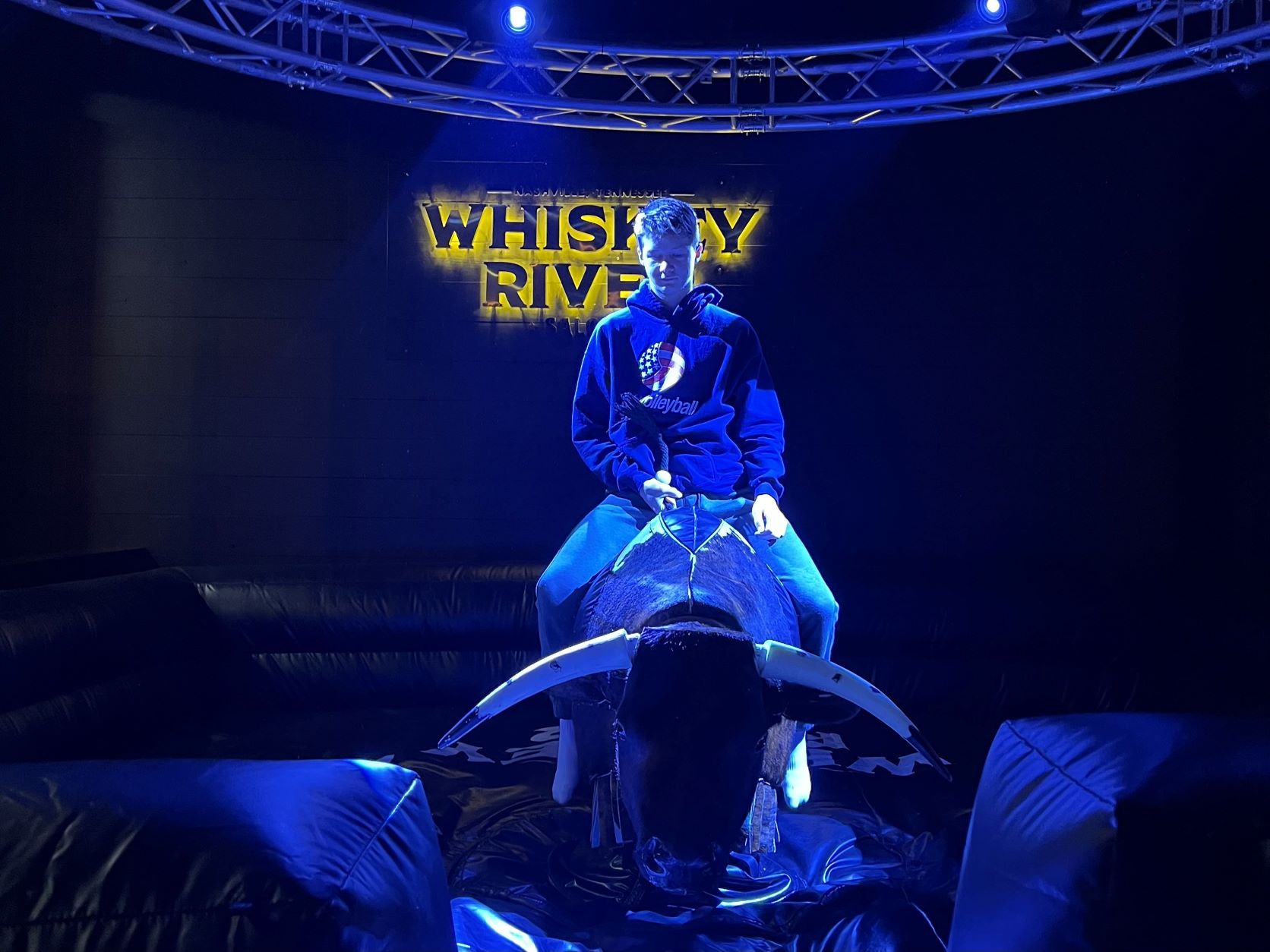 A teen rides a mechanical bull at Whiskey River in Nashville, Tennessee.