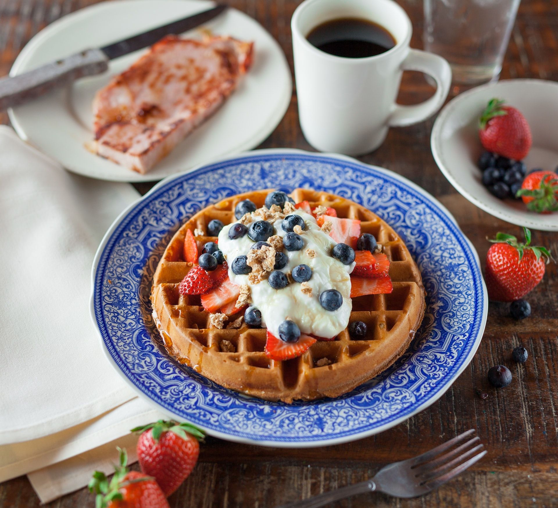 Waffles with blueberries, strawberries, and whipped cream.